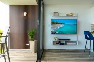 a living room with a flat screen tv on a wall at Trocean View, Amazing Ocean View in Rio Grande