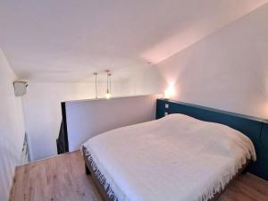 a bedroom with a bed with two lights on the wall at Magnifique logement d'architecte 3* sur Palavas in Palavas-les-Flots