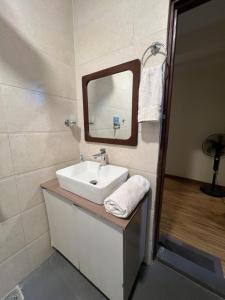 a bathroom with a sink and a mirror at Bodhiz Apartments in Kathmandu