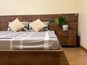 Un dormitorio con una cama grande con una planta. en Bodhiz Apartments en Katmandú