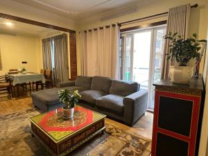 sala de estar con sofá y mesa en Bodhiz Apartments en Katmandú