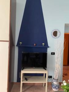 Elle comprend un salon doté d'une cheminée et d'un mur bleu. dans l'établissement A casa di Anna, à Vaglio Serra