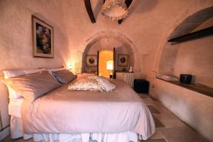 1 dormitorio con 1 cama blanca en una habitación en Trulli JaJa, en Alberobello