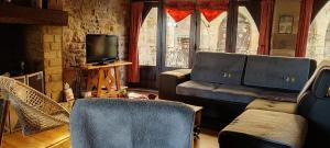 ein Wohnzimmer mit 2 Stühlen und einem TV in der Unterkunft Chambres d'hôtes l'Escuelle des Chevaliers in Cordes-sur-Ciel