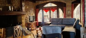 a living room with two couches and a tv at Chambres d'hôtes l'Escuelle des Chevaliers in Cordes-sur-Ciel