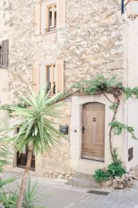 ヴァルボンヌにあるEntire townhouse in the heart of the villageの正面にヤシの木とドアがある建物