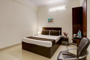 ein Schlafzimmer mit einem Bett und einem Stuhl darin in der Unterkunft OYO Flagship 35467 Shiridi Residency Near Birla Mandir in Hyderabad