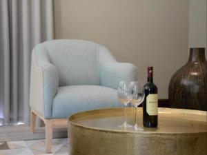 una botella de vino y dos copas de vino en una mesa en Chambray Estate - The Terraces in the Vines en Franschhoek