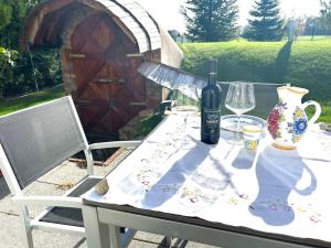een tafel met een fles wijn en glazen erop bij Apartman pri X Bionic Sphere Samorin s vínnou pivnicou in Blatná na Ostrove