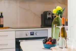 una encimera de cocina con un jarrón con flores y fruta en CASAS DA RUA NOVA en Alijó