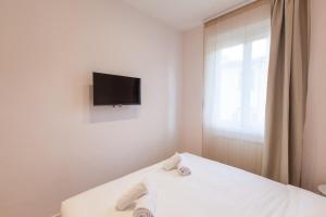 a bedroom with a bed with a tv on the wall at Santa Maria Novella Apartment in Florence