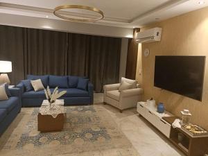 a living room with blue couches and a flat screen tv at حان الوقت الأن للاستمتاع بالهدوءبشقةفندقية متميزة بأطلالة على نيل الزمالك in Cairo