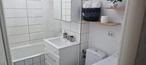 a white bathroom with a sink and a toilet at Feel Like Home 2 in Piatra Neamţ
