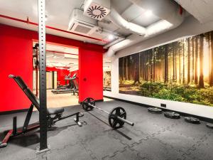 a gym with red walls and a painting of trees at Happy Valley Resort Szklarska Poręba in Szklarska Poręba