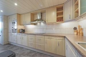 een keuken met houten kasten en een aanrecht bij Kabbelaarsbank 313 - Port Marina Zélande - not for companies in Ouddorp