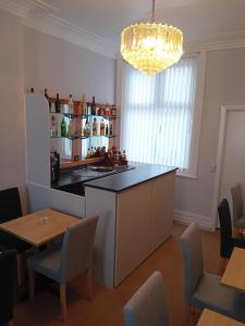 a kitchen with a counter and a table and chairs at Nathans Guest House in Blackpool