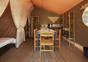 a room with a table and chairs in a tent at Camping Le Both d'Orouet in Saint-Jean-de-Monts