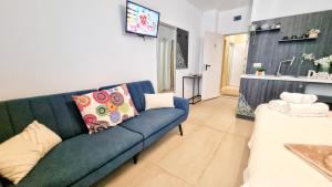 a living room with a blue couch and a kitchen at KYD VILA - Studiouri si Apartamente la 100m de Plaja Debarcader in Eforie Nord