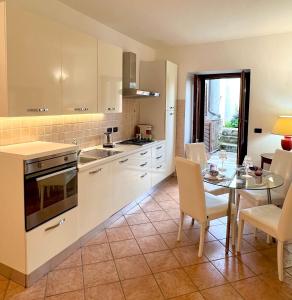 una cocina con armarios blancos y una mesa con sillas. en Vigna Rossa, en Bollengo