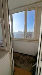 um quarto vazio com duas janelas e um tapete em Imanova 41 em Astana