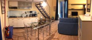a living room with a glass table and a kitchen at Guide Tour Apartments in Naples