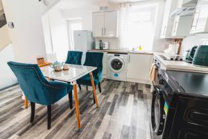 een keuken met een tafel en stoelen en een wasmachine bij A Perfect 1BD Getaway in Aberdare, South Wales in Aberdare