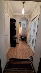um corredor de uma casa com um quarto com pisos de madeira em Imanova 41 em Astana