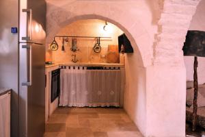 cocina con fregadero y nevera en Trulli JaJa Resort, en Alberobello