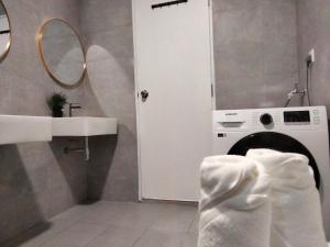 a bathroom with a washing machine and a sink at Bangsar South Botanical I Bed & Pillow in Kuala Lumpur