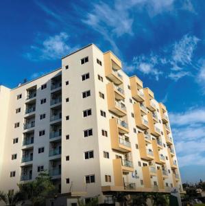 een hoog appartementencomplex met een blauwe lucht op de achtergrond bij Accra Luxury apartments at Oasis Park Residences in Accra