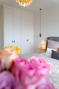 een slaapkamer met een bed met witte kasten en roze bloemen bij Ferienwohnung Königsmann in Strandnähe in Westerland