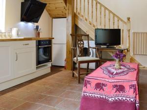 a kitchen with a table and a tv in a room at Hafotty Fach in Llanfyllin