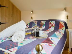 a bed with a blanket and a tray with a breakfast on it at Hafotty Fach in Llanfyllin