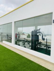 un edificio vacío con ventanas de cristal y césped verde en Accra Luxury apartments at Oasis Park Residences en Accra
