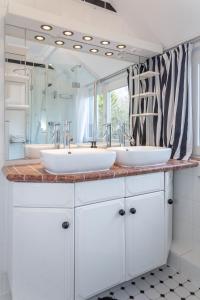 un bagno con due lavandini e un grande specchio di KleinKeitum a Keitum