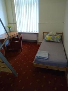 Pokój z łóżkiem, biurkiem i krzesłem w obiekcie Hostel Kwadrans w mieście Gliwice