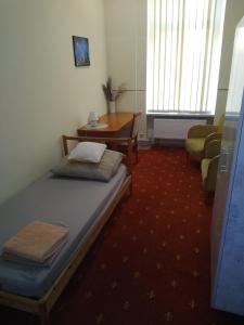 Zimmer mit einem Bett, einem Tisch und einem Stuhl in der Unterkunft Hostel Kwadrans in Gliwice