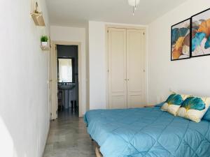 een slaapkamer met een blauw bed in een kamer bij Apartamento La cala 2 in Cala del Moral