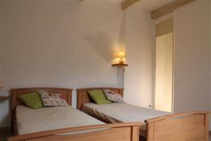 1 dormitorio con 2 camas y espejo en Gîte de la font d'Arlane, en Viviers