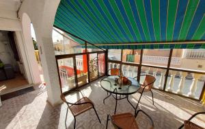 eine Terrasse mit einem Tisch und Stühlen auf dem Balkon in der Unterkunft Haus Mundo La Marina Urbanisation in San Fulgencio