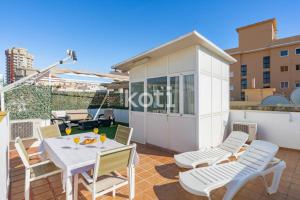 patio ze stołem i krzesłami oraz budynek w obiekcie Koti Rentals - Ático Gamycol w mieście Fuengirola