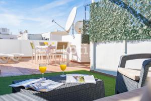 stół z dwoma kieliszkami soku pomarańczowego na patio w obiekcie Koti Rentals - Ático Gamycol w mieście Fuengirola