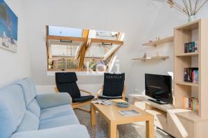 sala de estar con sofá azul y 2 sillas en Koti Rentals - Ático Gamycol en Fuengirola