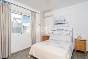 Habitación blanca con cama y ventana en Koti Rentals - Ático Gamycol en Fuengirola