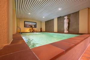 una piscina con una estatua en un edificio en Toni's Alpine Loft, en Kandersteg