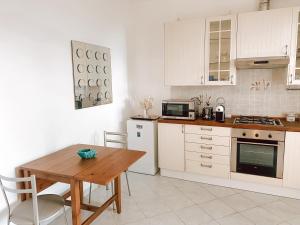 une cuisine avec des placards blancs et une table en bois dans l'établissement Il Nido sullo Scoglio, à Bonassola