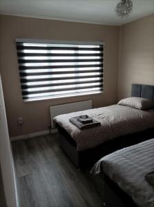 um quarto com 2 camas e uma grande janela em Iacomm Lucan 3 bed em Lucan