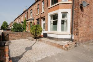 a brick house with a tree in front of it at Well located 3 bedroom home in central Chester with Parking in Chester
