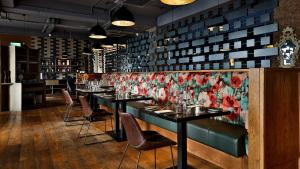 a dining room with tables and chairs and a floral wall at Midlands Park Hotel in Portlaoise