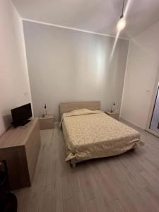 um quarto com uma cama e uma televisão de ecrã plano em Casa Vacanza Mondello em Palermo